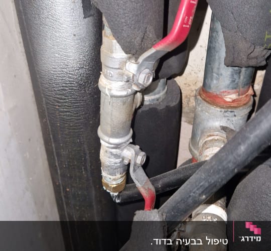 צינורות עם ברזים אדומים במערכת חימום